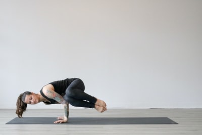 穿着黑色背心和灰色紧身裤的女人在做瑜伽